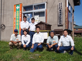 事務所をバックに集合写真