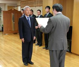 山﨑局長から感謝状を受け取る尾崎 代表世話人