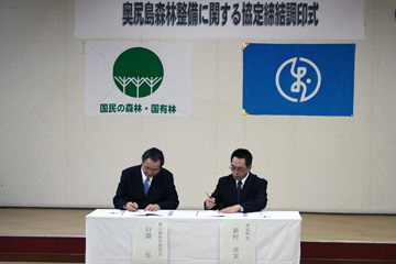 協定書に署名をする新村町長（右）と白淵署長（左）
