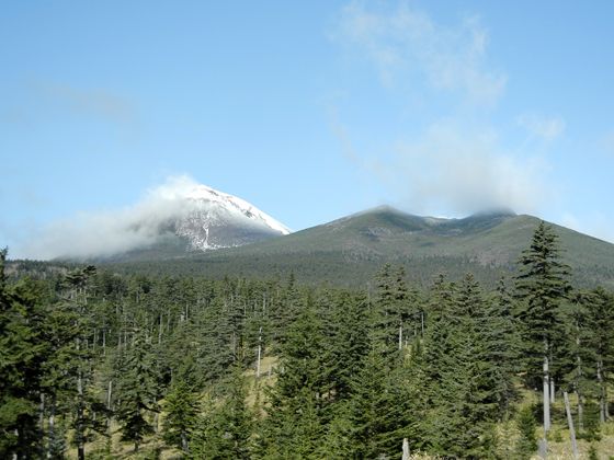 左側（阿寒富士）の山頂近辺に雪が積もっています