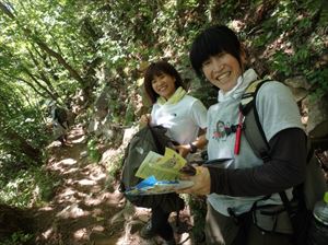 リーフレットと携帯トイレを手に取る登山客