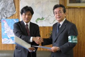 協定書締結時に握手を交わす北海道新聞社経営企画室 阪井 宏 環境専任部長（左）と山形 胆振東部森林管理署長（右）