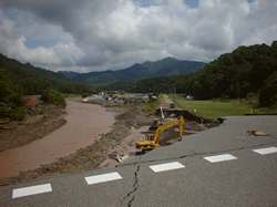 河川沿いの道路のコンクリートが崩落している写真