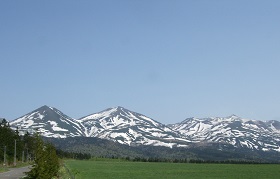 雪の残った美瑛富士から十勝岳までが写った写真