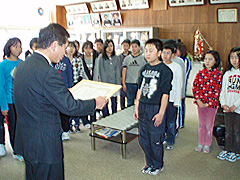 常呂小学校で 洞下（ほらげ）網走中部森林管理署長から感謝状を受け取る学級委員長の木村君と5年生のみなさん