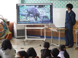 センサーカメラに写った野生動物を見る児童たち