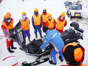 スノーモビルのエンジンルームを開けての説明