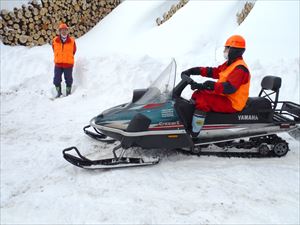 新規採用職員がスノーモビルを運転、ベテラン職員は見守ります。