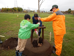 記念植樹を行った村局長とながぬま緑の少年団と岩見沢農業高等学校の皆さん