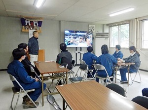 工場で行われている作業について動画で説明を受ける様子