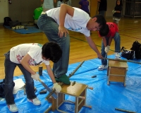 のこぎりで材料を切断中