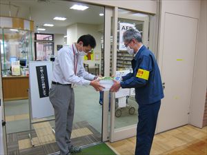 旭川市神楽図書館の岳館長に冊子を手渡す近藤署長