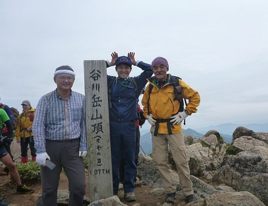 左端が筆者（職員と登頂）