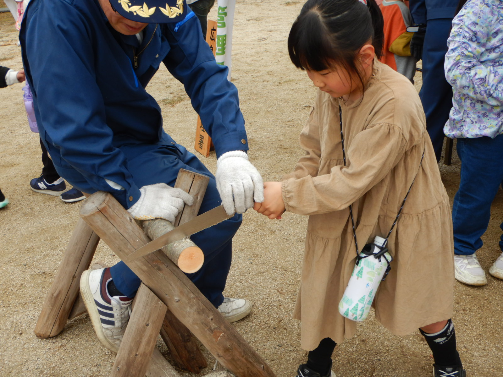 丸太切りをする子ども