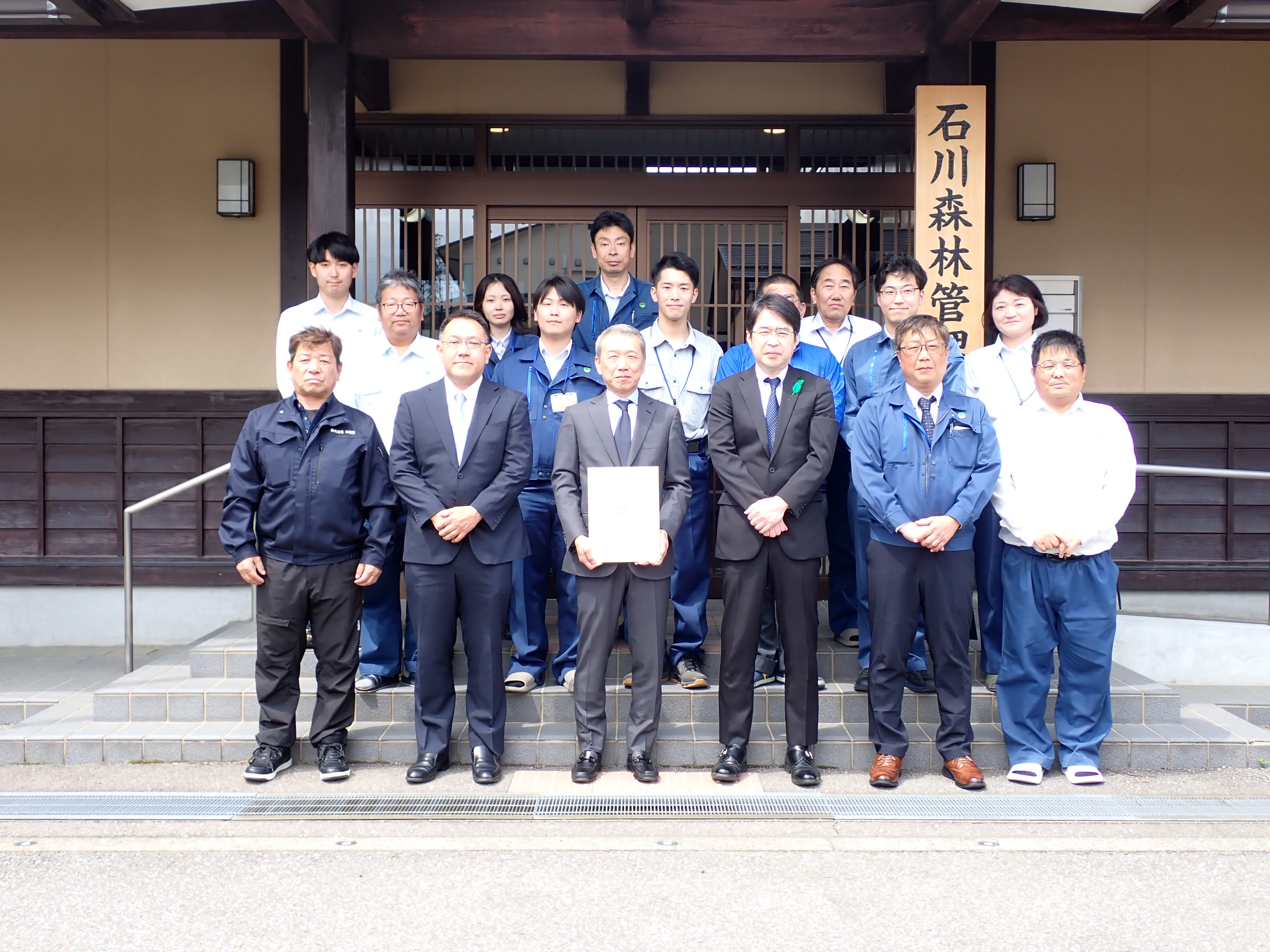庁舎玄関前で職員とともに記念撮影