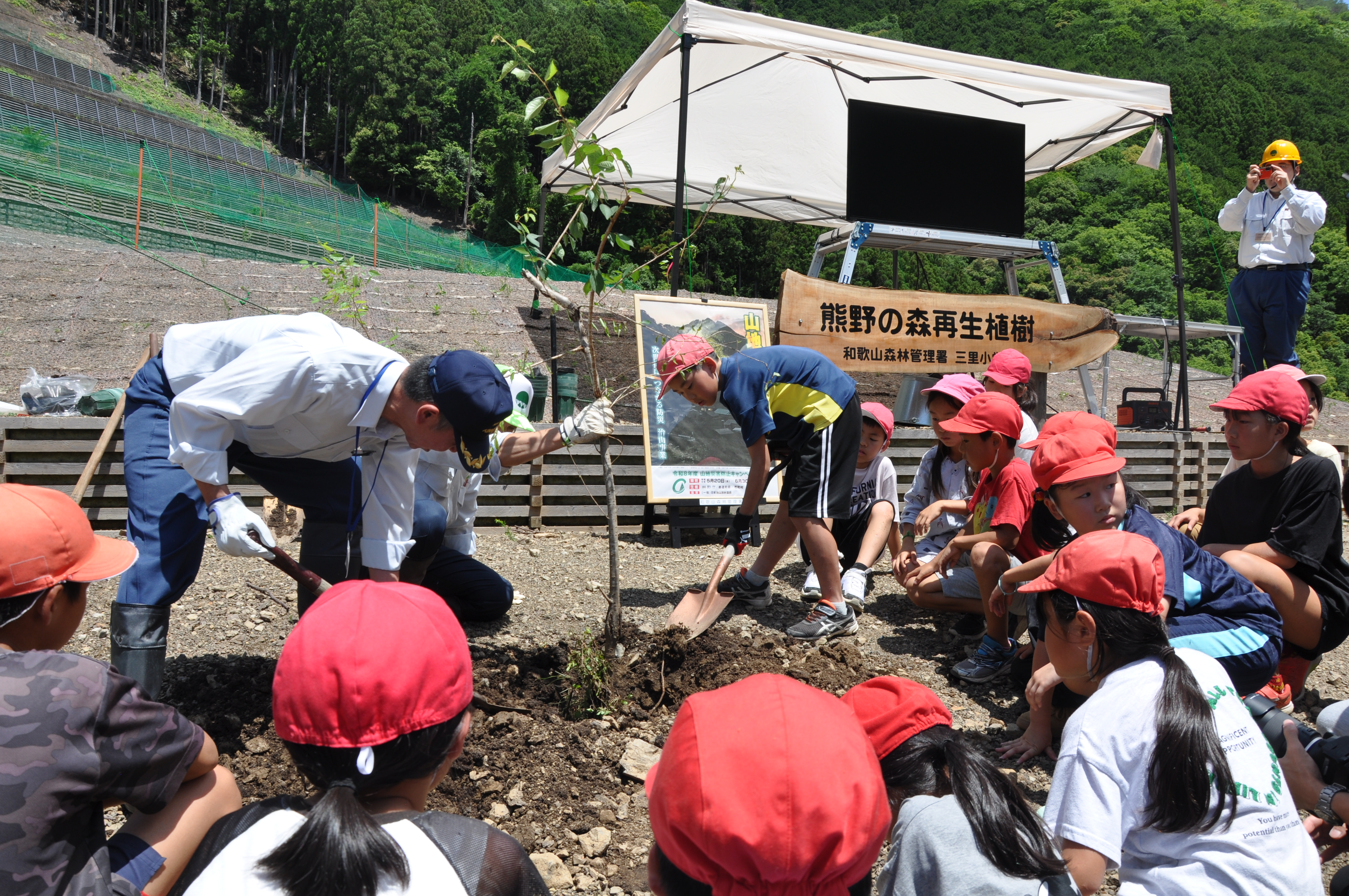 サクラを植える署長と児童会長