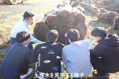 土埋木を実際に触り説明を受ける様子